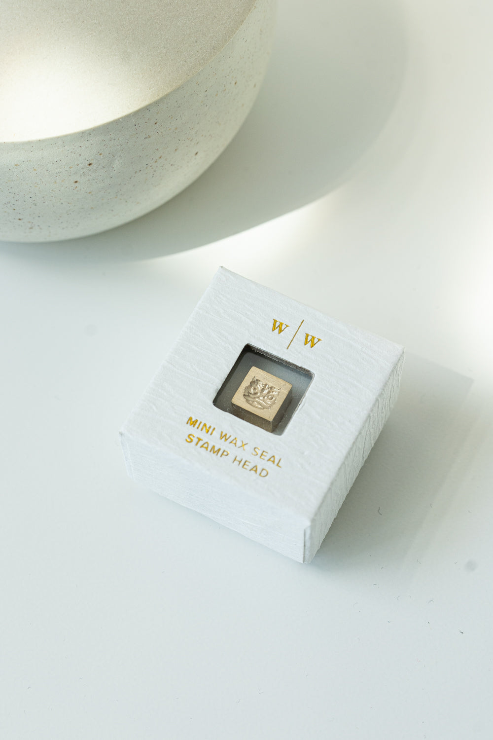 A square mini wax seal head packaged in a white ring-style box with a Lion Dance Head design on a white surface