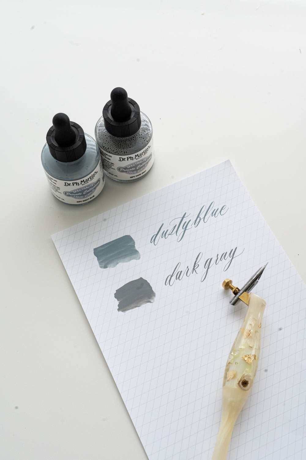 Dusty blue and dark gray calligraphy ink swatches with oblique pen on grid paper, Dr Ph Martin’s calligraphy ink