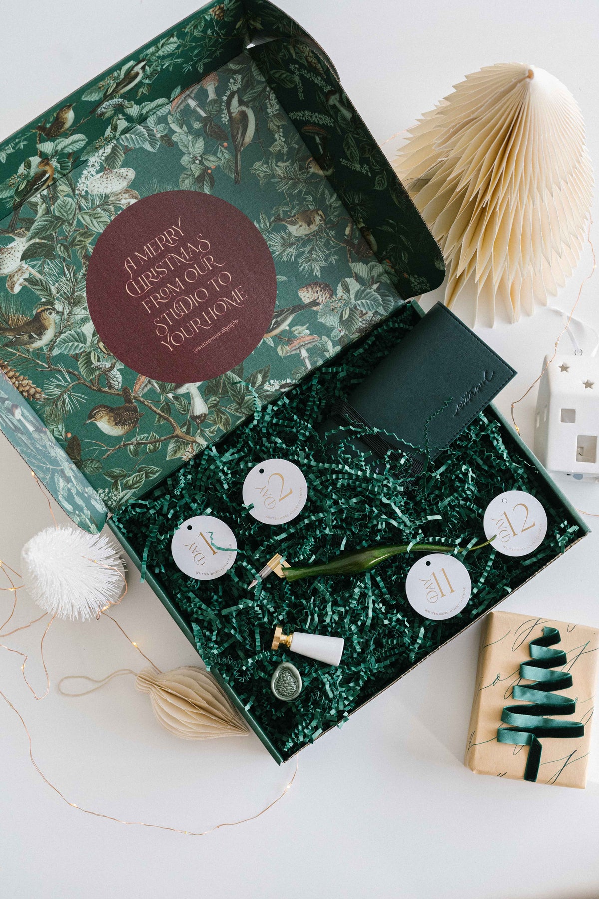 Calligraphy and wax seal tools inside holiday advent calendar box with festive packaging and decor