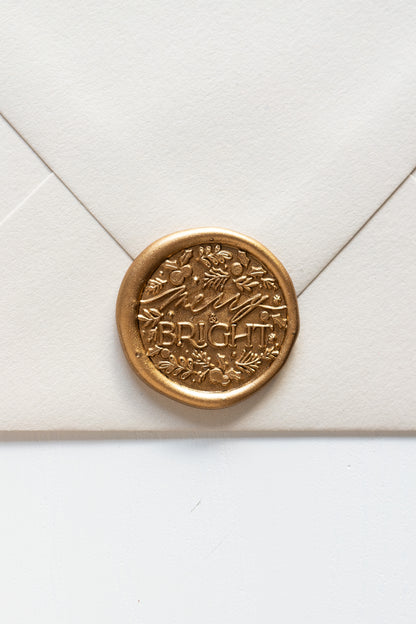 Gold wax seal impression with detailed botanical design on envelope, festive wax seal stationery
