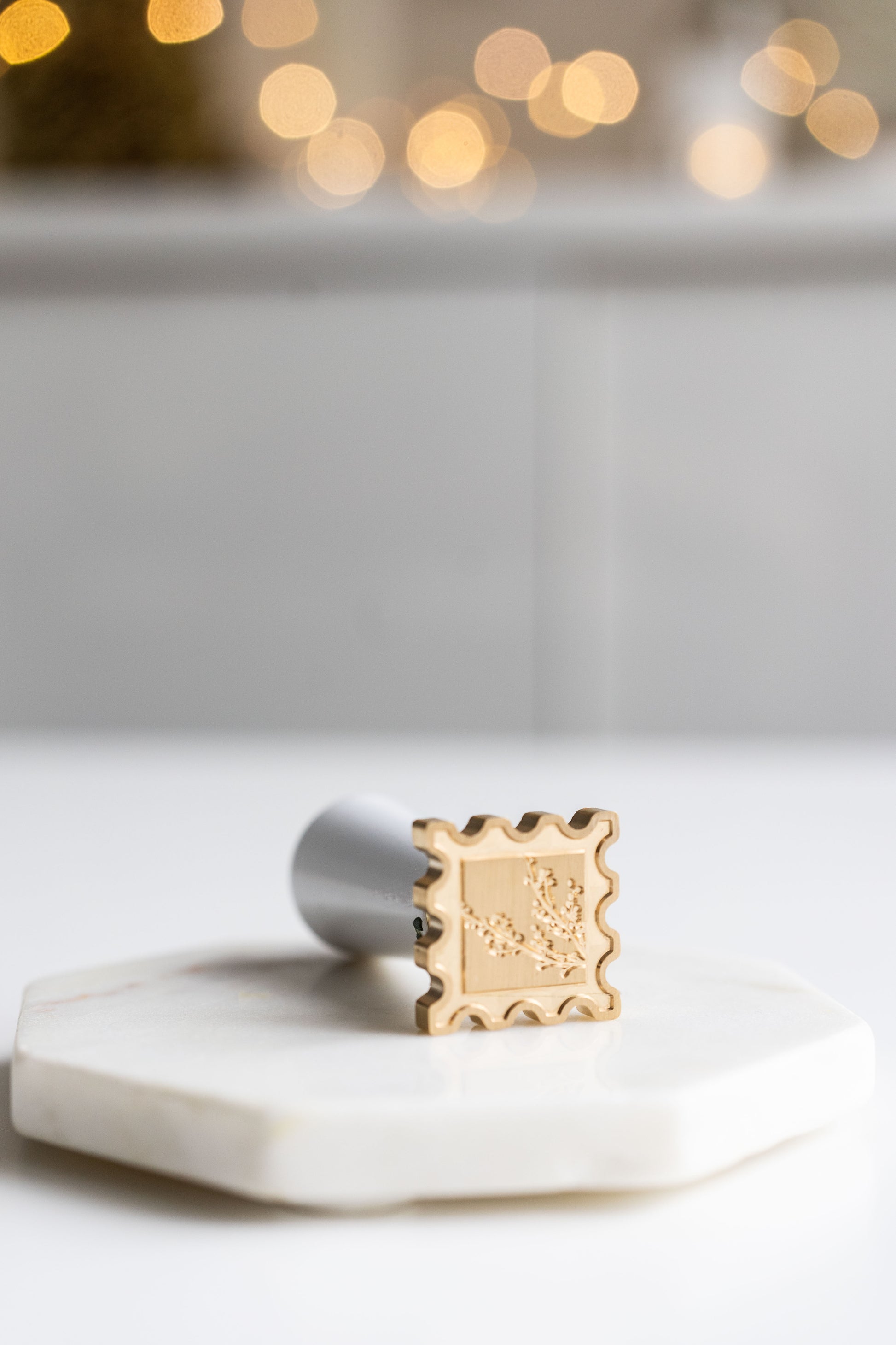 Brass wax seal stamp head with winterberries engraving on marble surface, calligraphy wax seal tool