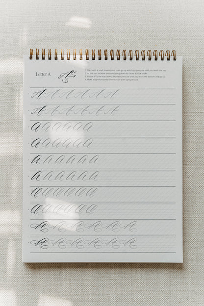 Calligraphy practice sheet featuring instructions and drills for writing the letter 'A' in five uppercase calligraphy styles