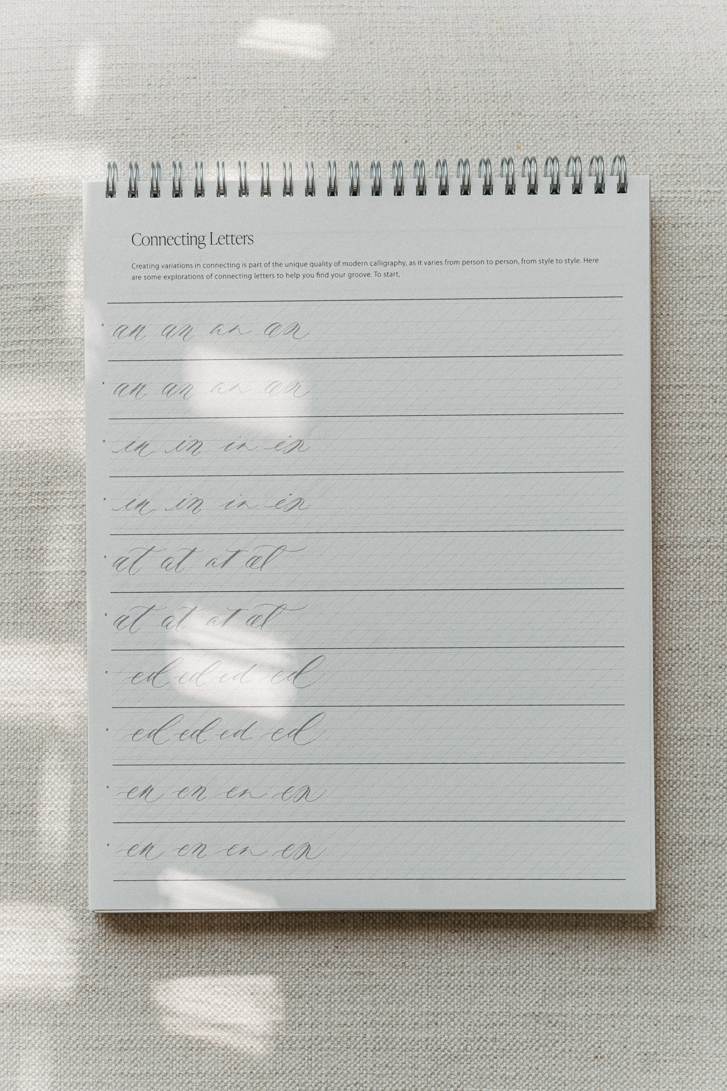 Calligraphy practice pad focusing on connecting letters, featuring various letter combinations for improving handwriting flow and style