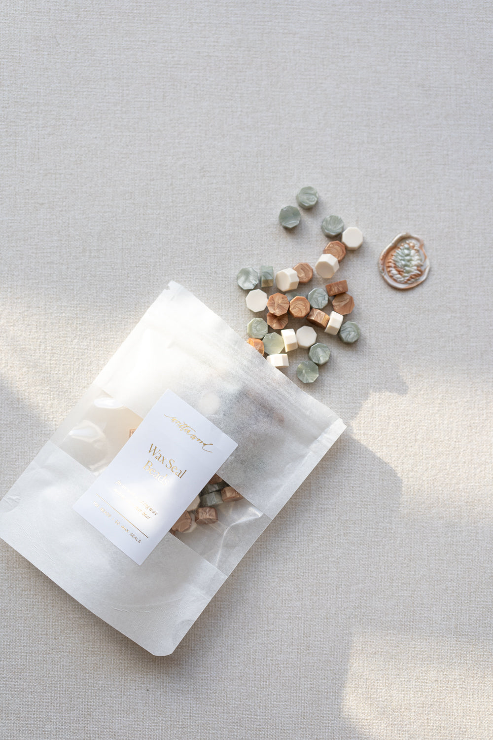 Cozy Pine wax seal beads in sage green, ivory, and copper tones with packaging and finished wax seal example