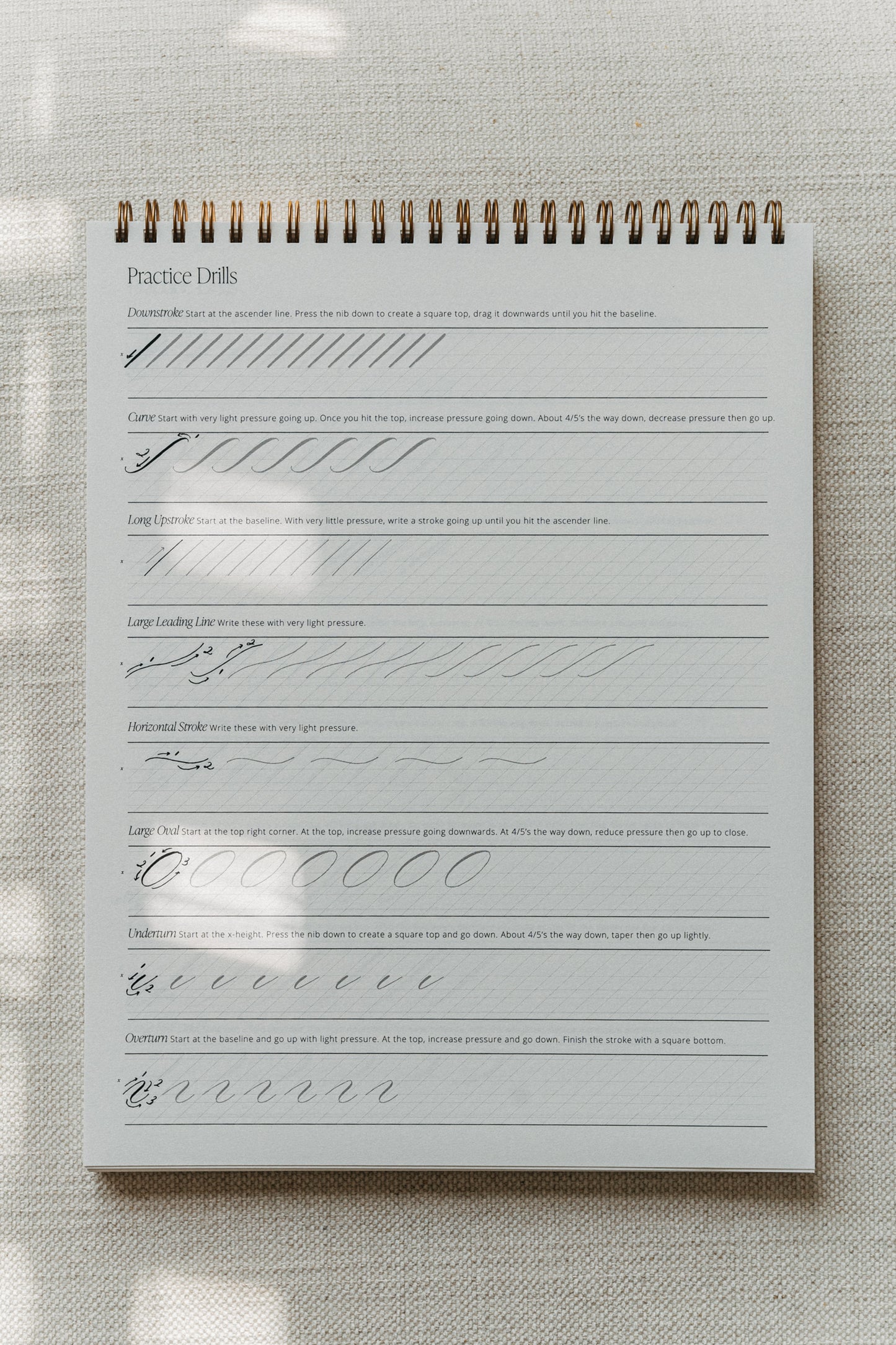 Calligraphy practice pad with drills for downstrokes, curves, and various strokes for beginners