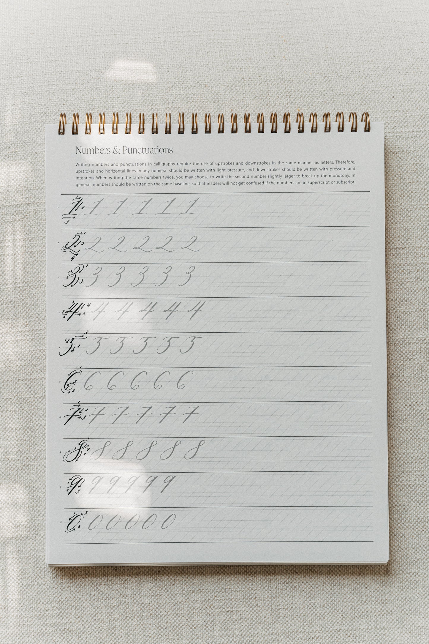 Calligraphy practice pad with drills for numbers and punctuation, focusing on upstrokes and downstrokes