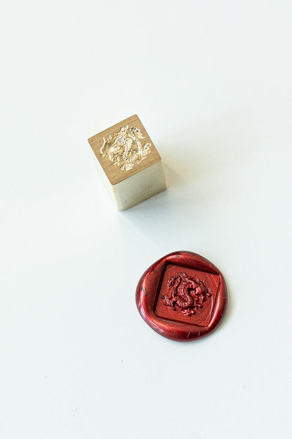 A square mini wax seal with a dragon engraved with a red wax seal showcasing the design
