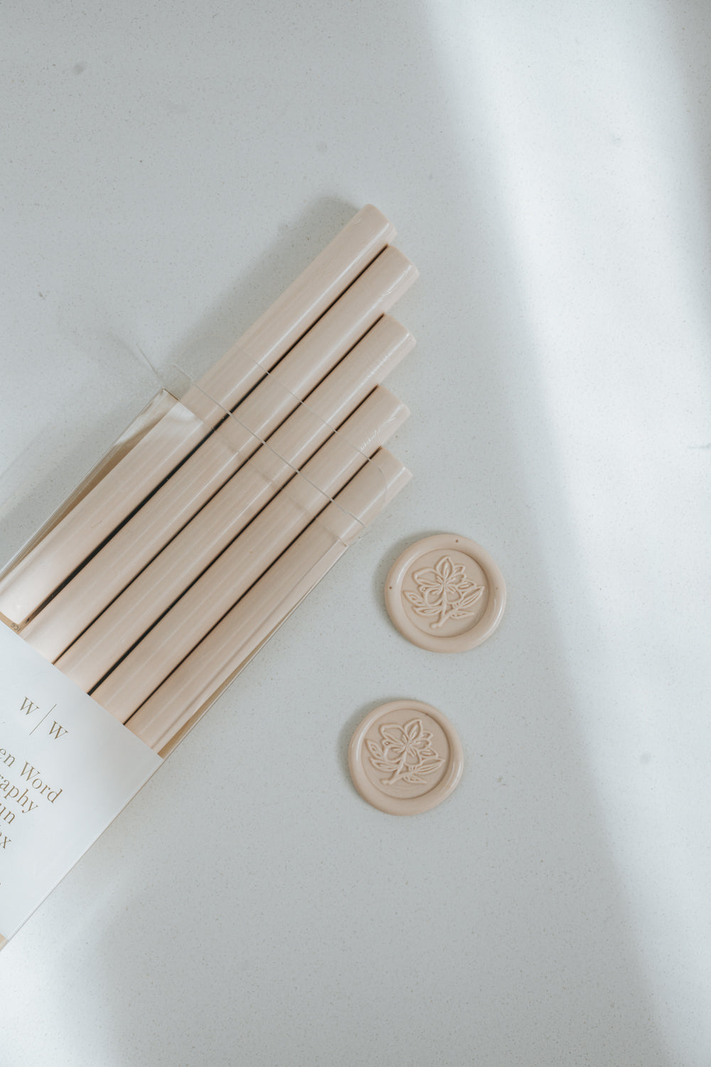 Bundle of Sakura pink wax sticks with two matching wax seals stamped with a magnolia flower design on a light surface