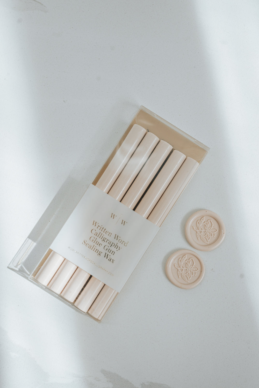 Bundle of Sakura pink wax sticks with two matching wax seals stamped with a magnolia flower design on a light surface