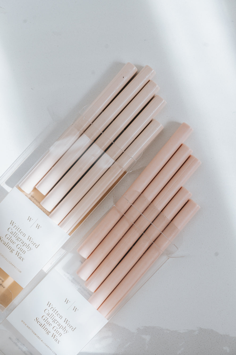 Comparison between a bundle of Sakura wax sticks and a bundle of Blush Wax Sticks on a light surface