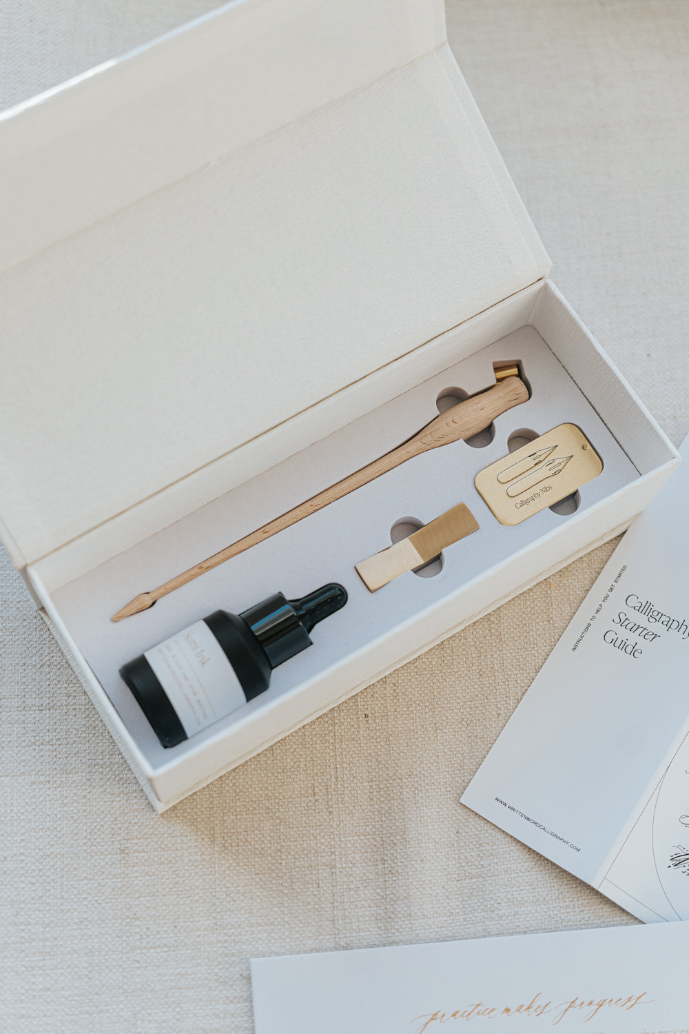 Elegant Mini Calligraphy Starter Kit with wooden pen holder, sumi ink, nibs, and guide, perfect for beginners in script writing.