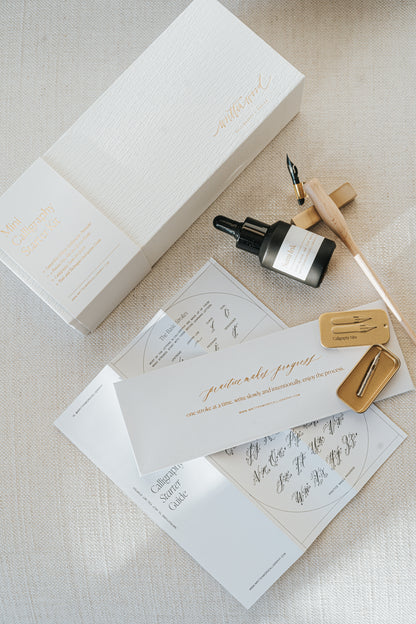 Mini Calligraphy Starter Kit with luxury packaging, sumi ink, calligraphy pen, nibs, and guide, elegantly displayed on fabric