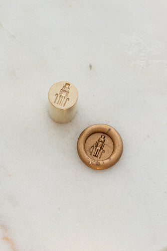 Close-up of classic wax seal stamp featuring a nutcracker design in gold wax, from Written Word Calligraphy’s Holiday Collection.