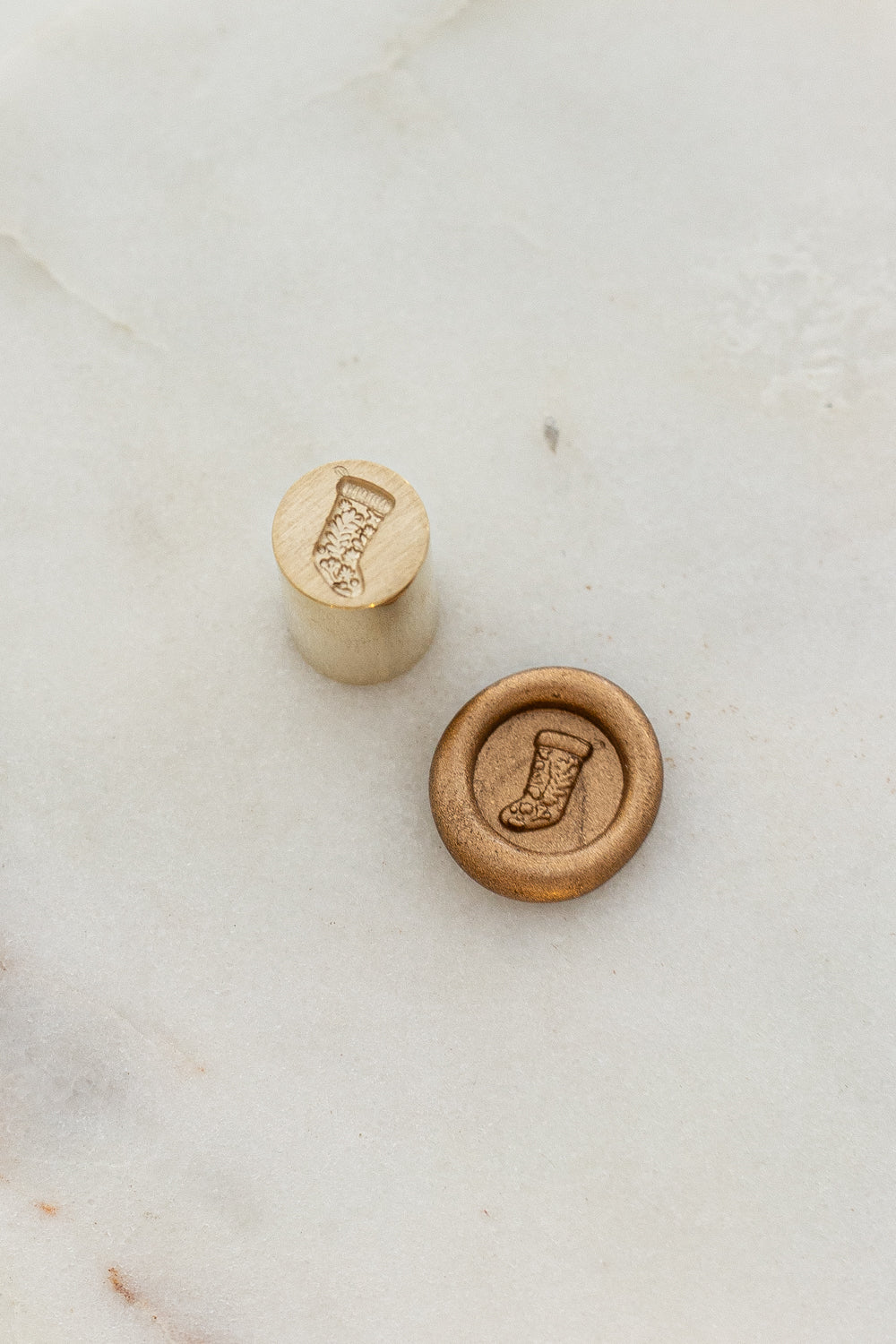 Close-up of mini wax seal stamp with Christmas stocking design in gold wax, part of Written Word Calligraphy’s Holiday Collection.
