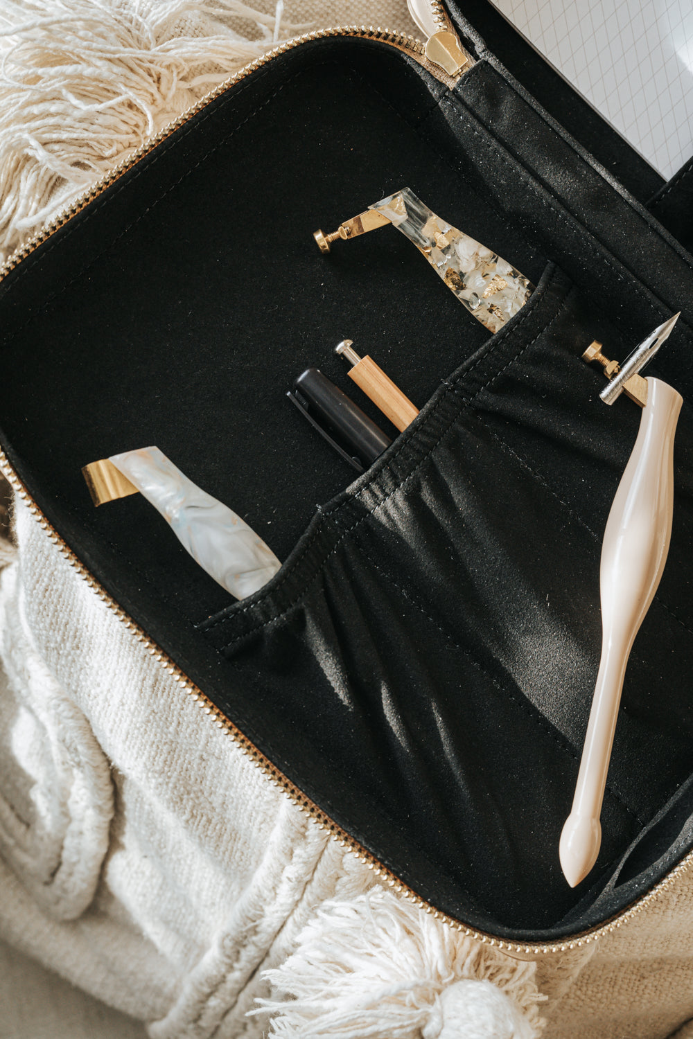 A calligraphy travel kit opened and filled with calligraphy supplies 