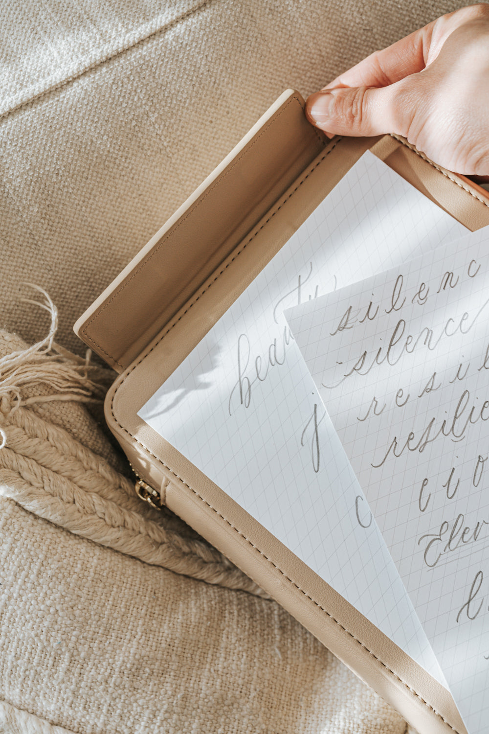 A beige travel case with a slanted guide paper sheets on a beige couch