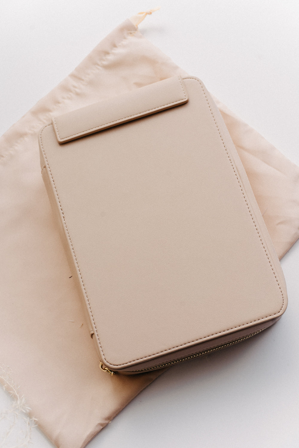 A beige calligraphy travel kit on a beige dust bag on a white surface