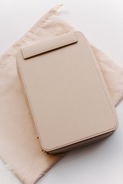 A beige calligraphy travel kit on a beige dust bag on a white surface