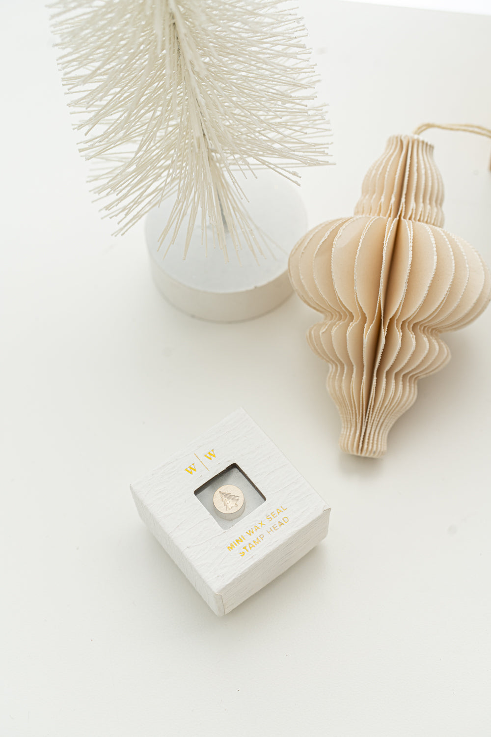 Limited edition wax seal stamp of a 3d illustration of a Christmas Tree in a white ring style box.