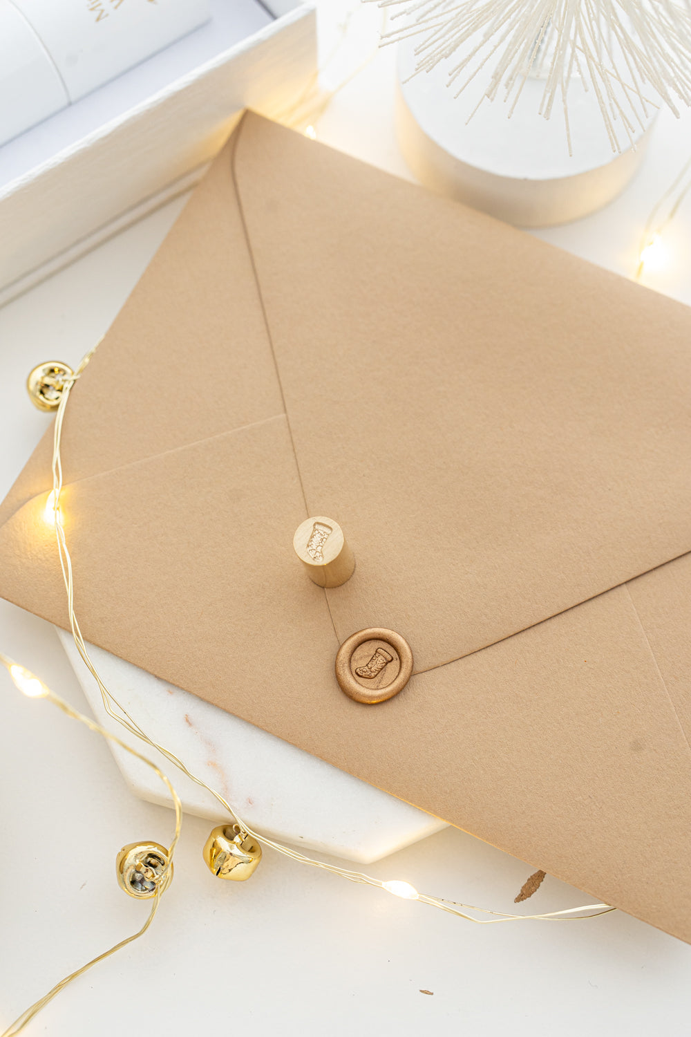Mini wax seal stamp with Christmas stocking design in gold wax on a kraft envelope, part of Written Word Calligraphy’s Holiday Collection.