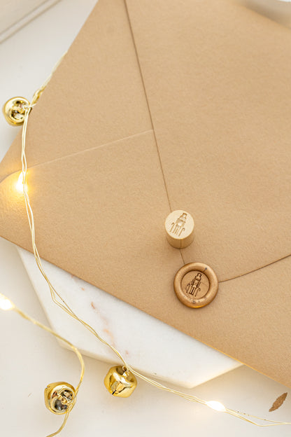 Elegant holiday mini wax seal stamp with nutcracker design in gold wax on a kraft envelope, part of Written Word Calligraphy’s Holiday Collection.
