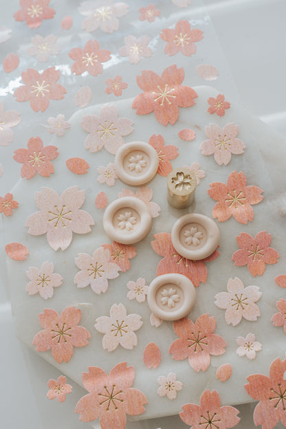 Mini cherry blossom wax seal impressions with brass stamp and cherry blossom background