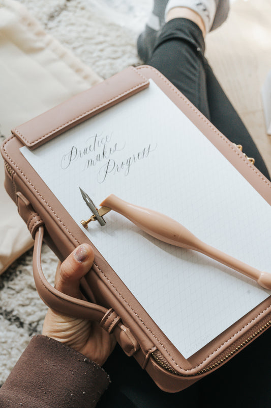 Dusty rose calligraphy travel case with practice pad and oblique pen, portable lettering setup for practicing modern calligraphy