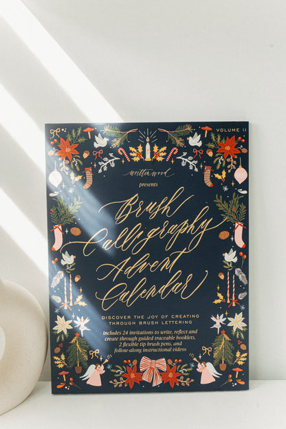 Front view of Brush Calligraphy Advent Calendar Volume II, a Christmas brush lettering kit with 24 creative prompts.