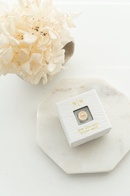 Limited edition wax seal stamp of a 3d illustration of a basket of eggs in a white ring style box.