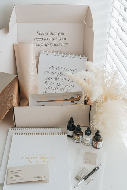 Complete modern calligraphy kit with practice pad, inks, nibs, pen holder, and worksheets