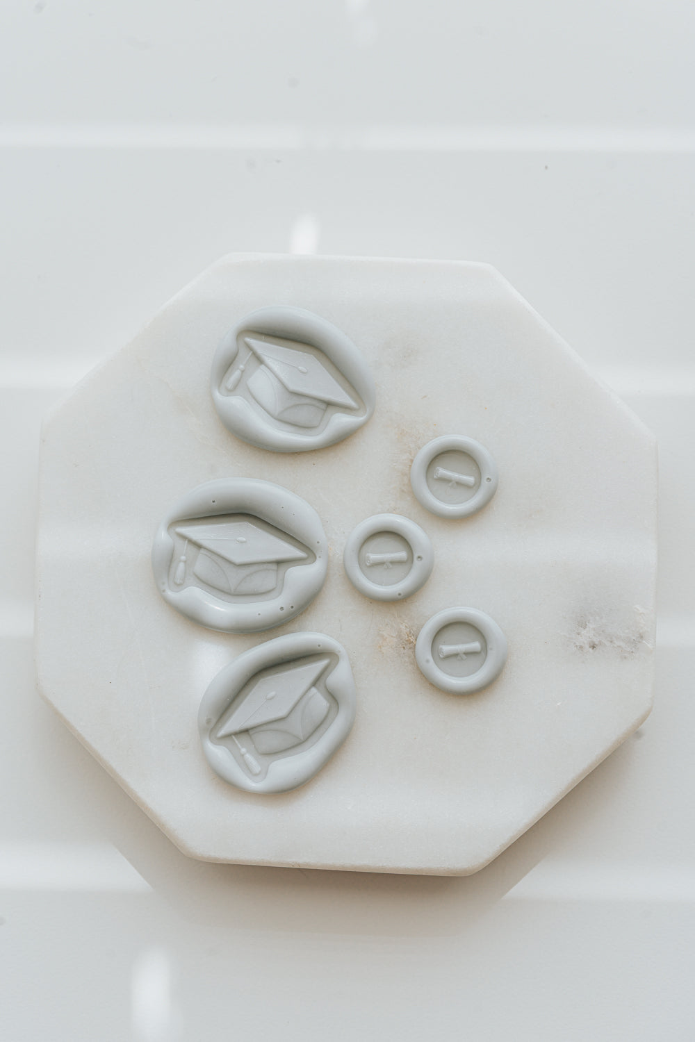 Set of pale gray graduation wax seals with cap and diploma designs