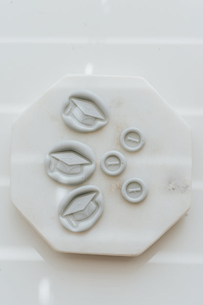 Set of pale gray graduation wax seals with cap and diploma designs