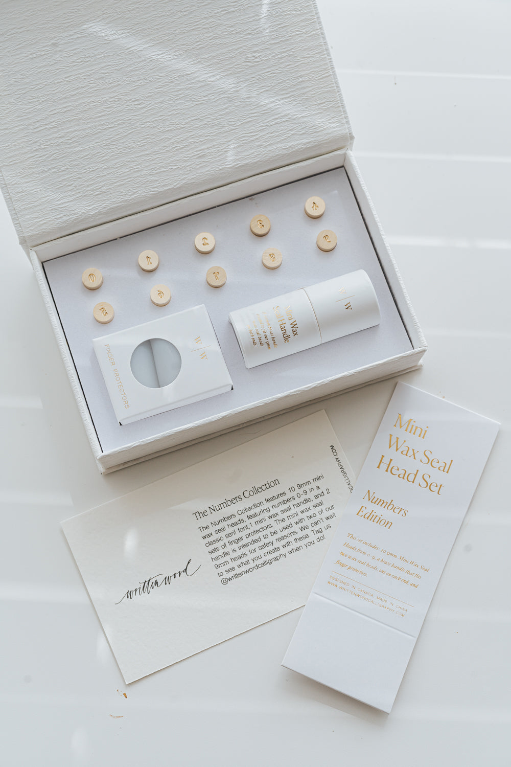 Flat lay of mini wax seal number set with branded box and inserts