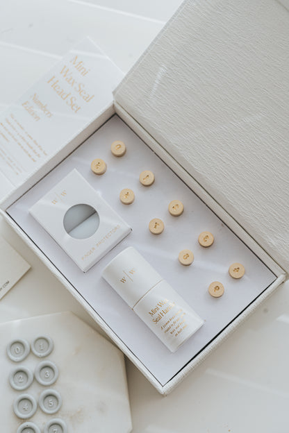 Open box showing mini wax seal number heads, handle, and finger protectors in premium packaging