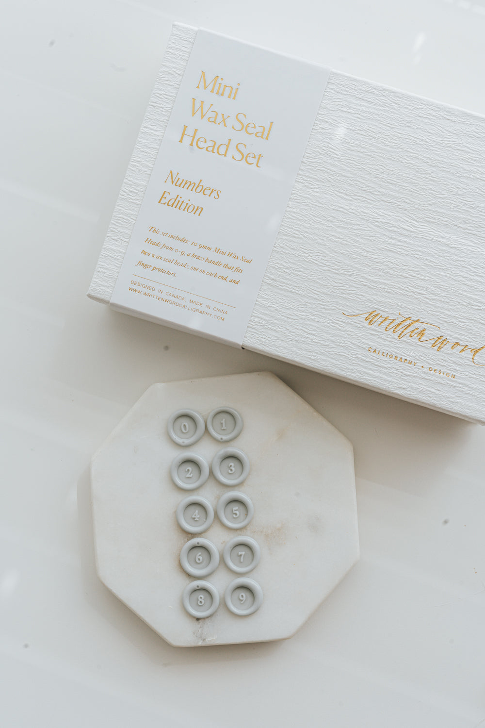 Mini wax seal head set numbers edition with clear wax seals 0 to 9 on marble tile and branded box