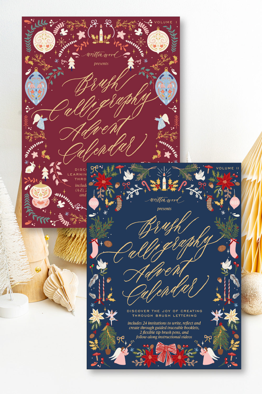 Brush Calligraphy Advent Calendar Volume I and Volume II bundle, burgundy and navy covers with festive illustrations and gold lettering by Written Word
