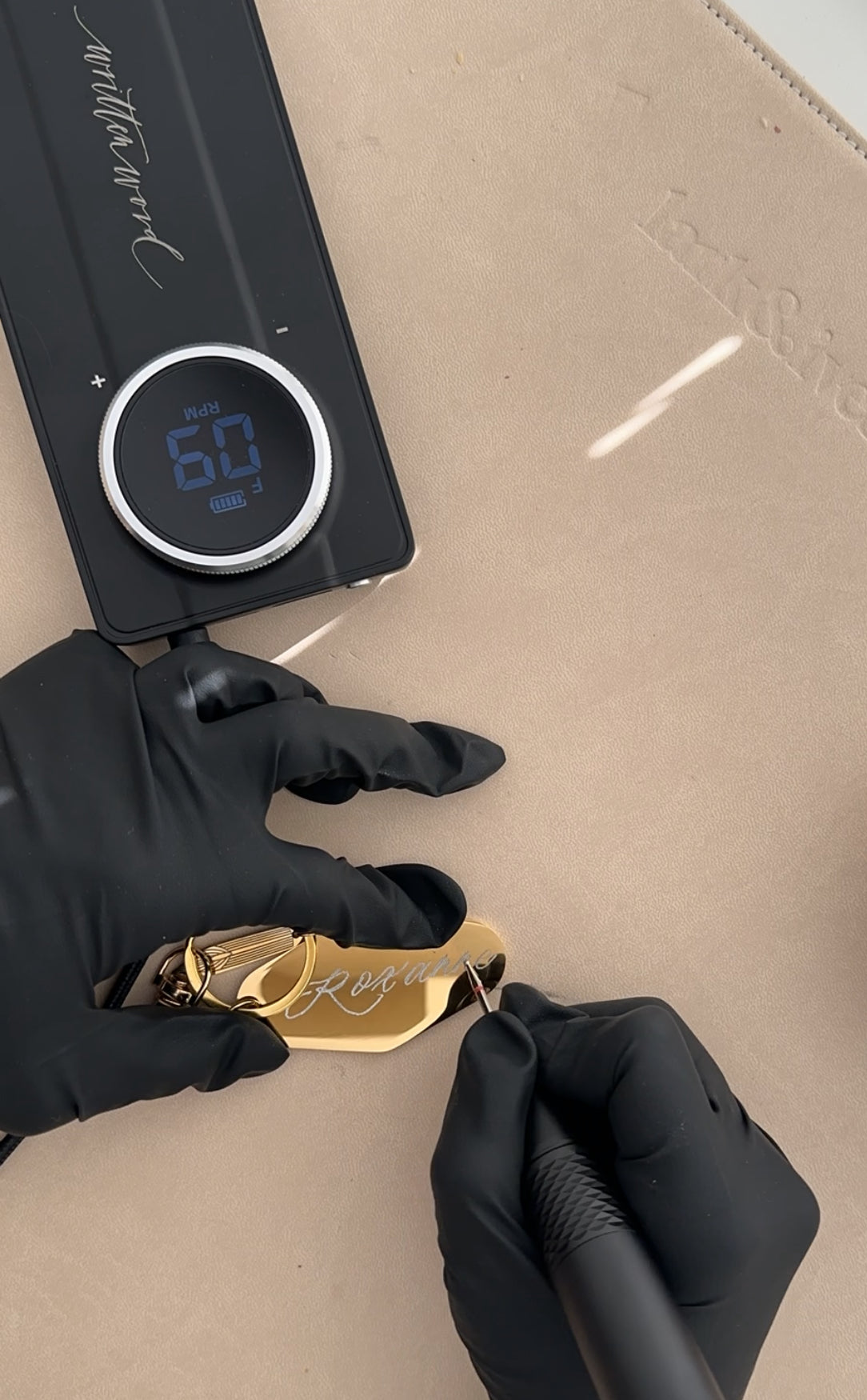 Custom metal motel keychain being engraved with a handwritten calligraphy name using a precision engraving machine, personalized gift keychain handmade in Vancouver, Canada.