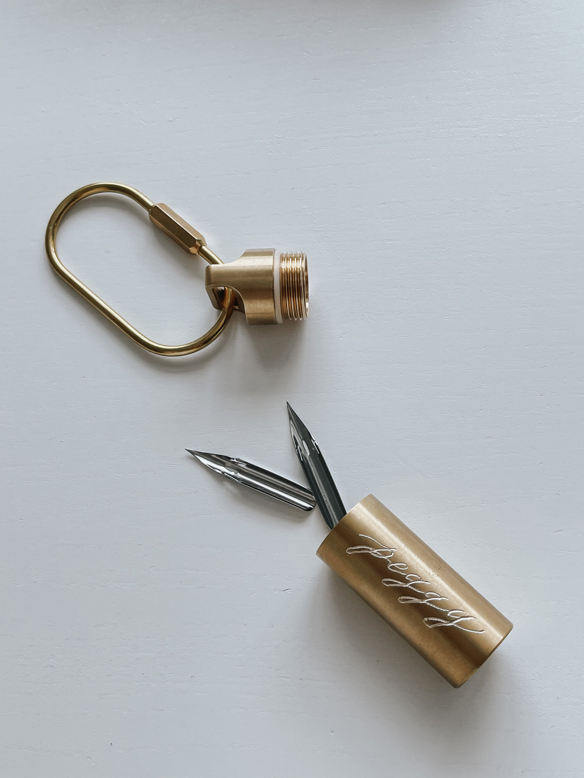 Custom engraved brass nib container keychain with interchangeable calligraphy nibs, personalized calligraphy tool accessory for lettering artists, writers, and stationery lovers.