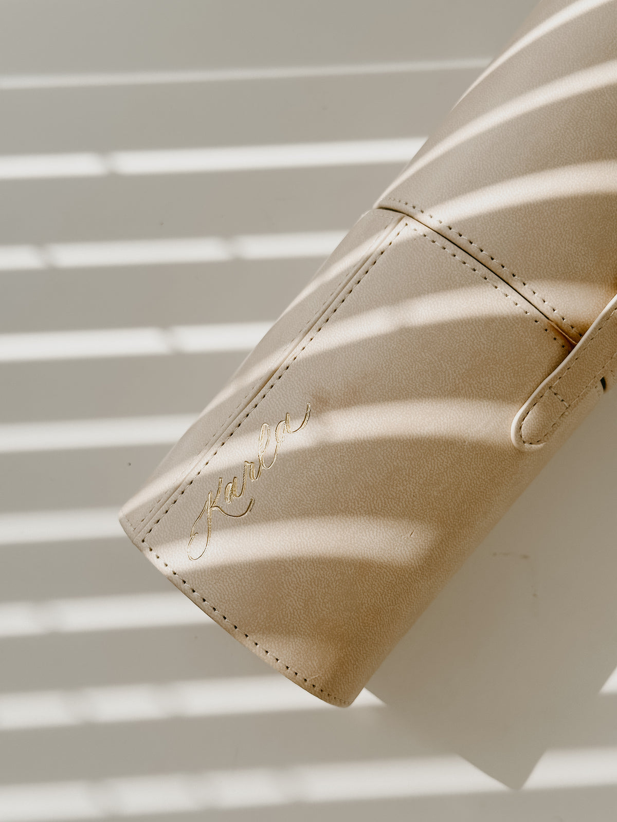Custom engraved beige vegan leather pen roll with handwritten calligraphy name personalization, elegant storage case for calligraphy pens, brushes, pencils, and stationery supplies.