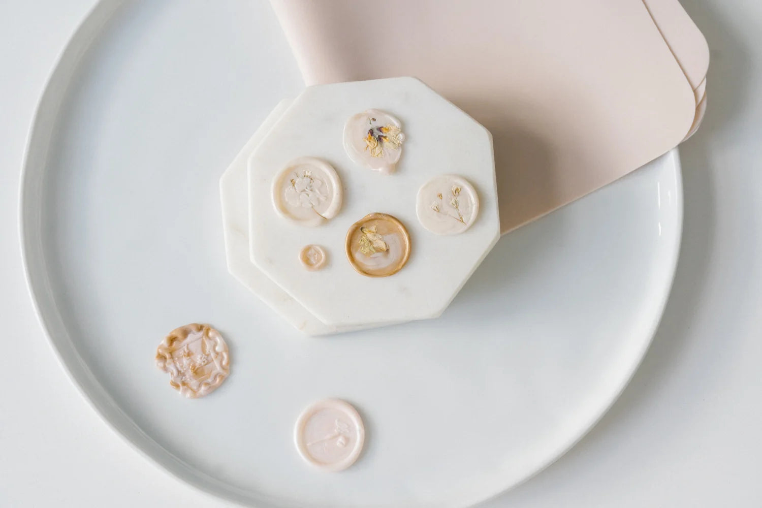 Floral wax seal examples with dried flowers and botanical designs on stationery, showcasing creative wax sealing ideas for letters and invitations