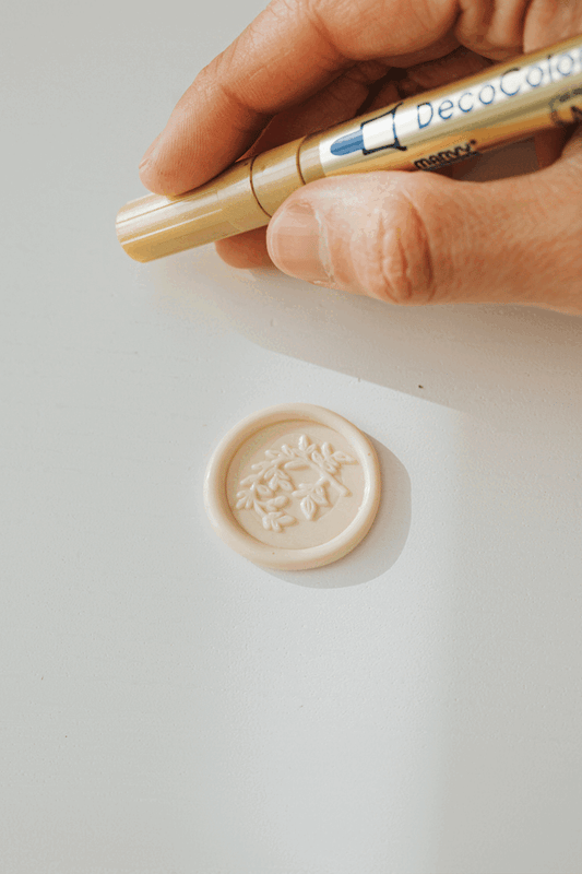 Marvy Uchida DecoColor Premium Fine Point gold paint pen with a beige wax seal