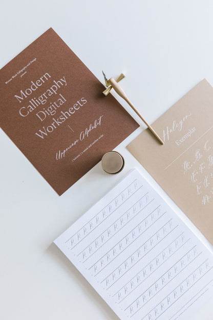 Calligraphy worksheet set with uppercase alphabet, pen holder, and ink for practicing letterforms