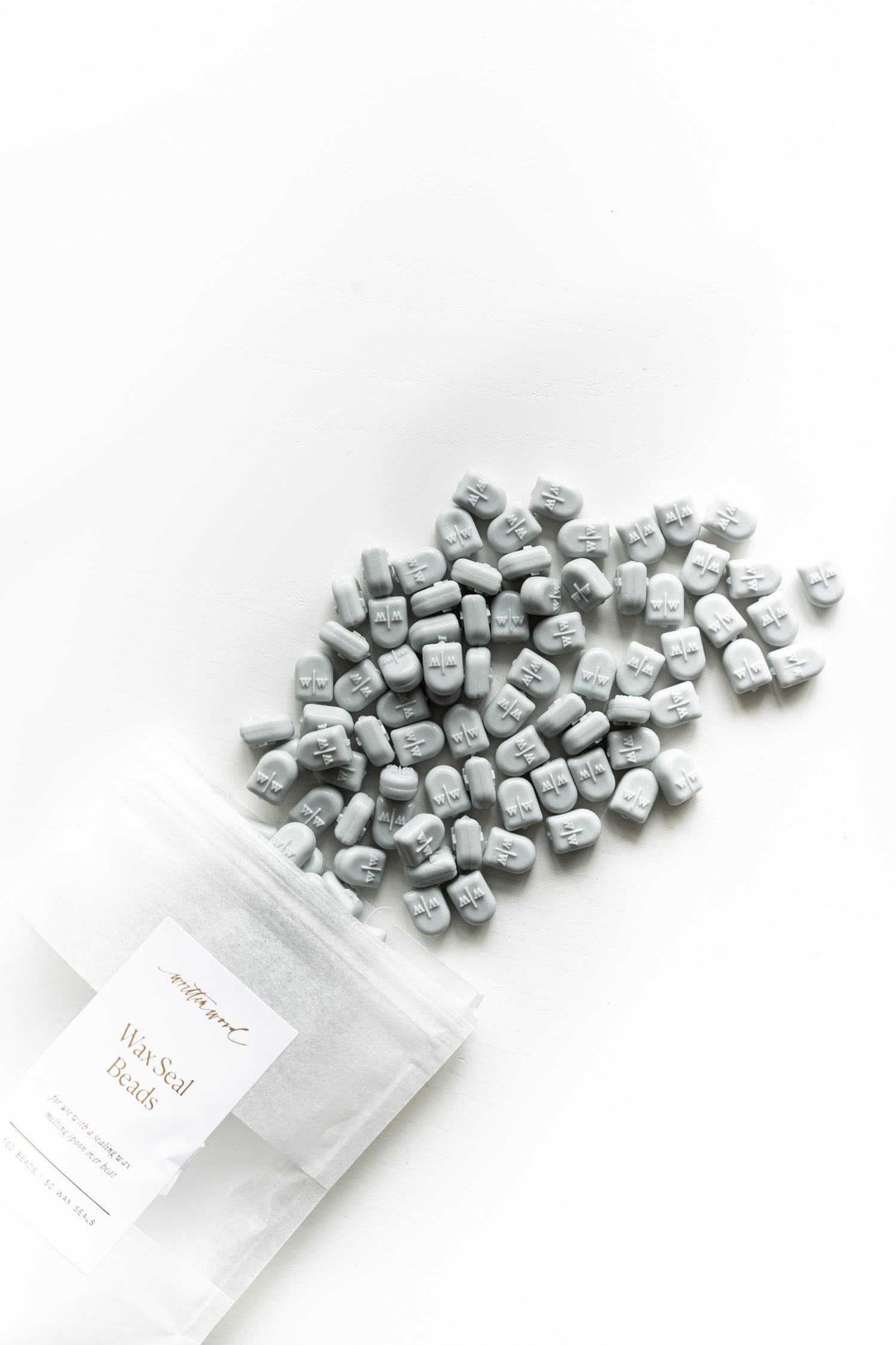 Pale grey sealing wax beads scattered for wax seals on wedding invitations and stationery