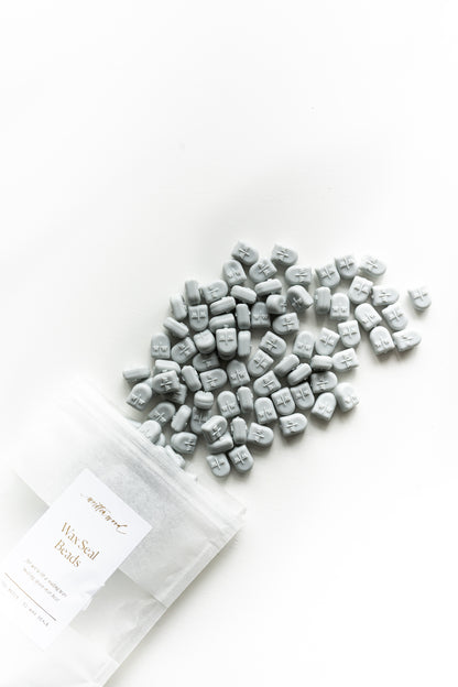 Pale grey sealing wax beads scattered for wax seals on wedding invitations and stationery