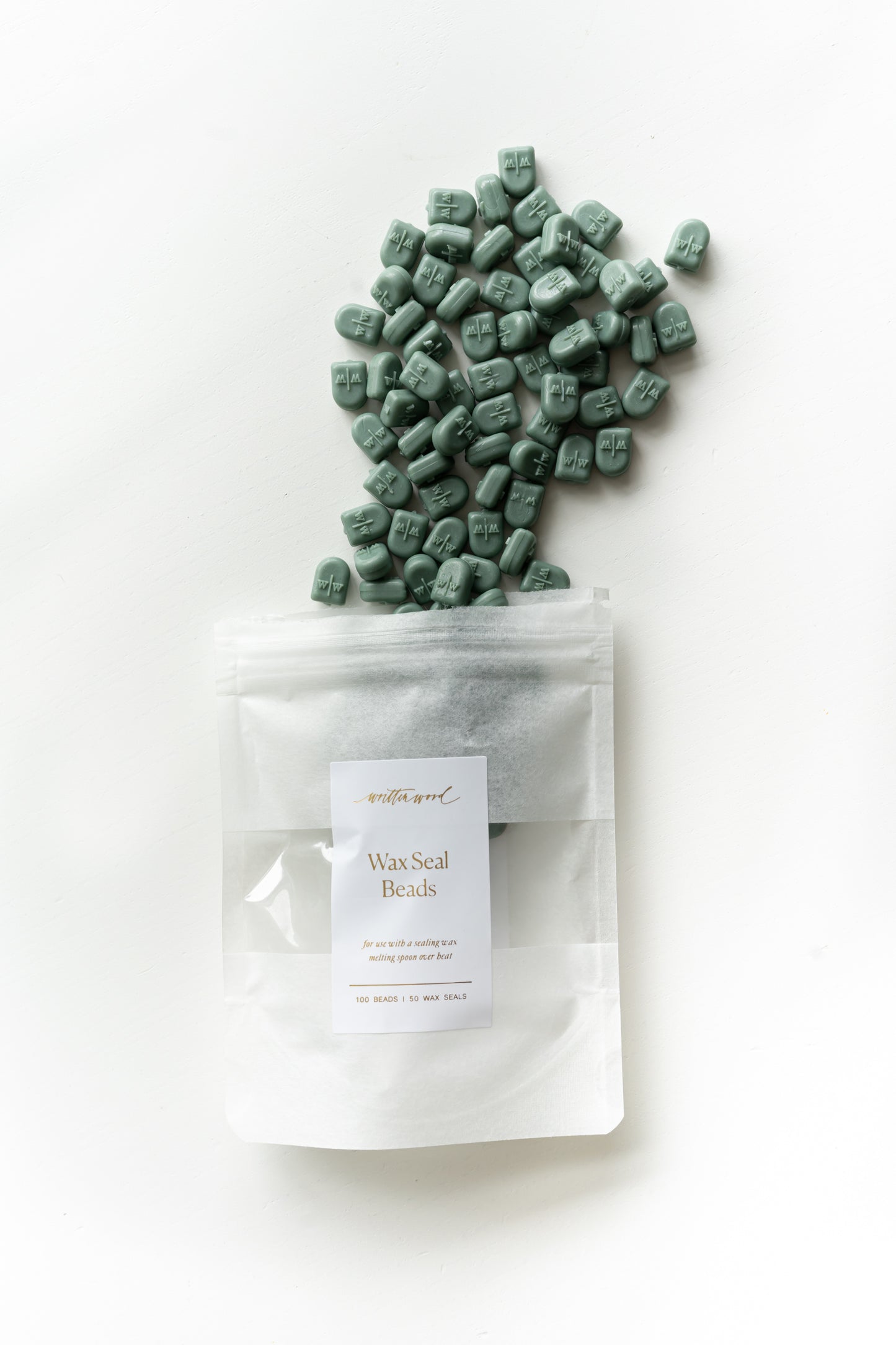 Forest green wax seal beads pouring from pouch for wax sealing projects