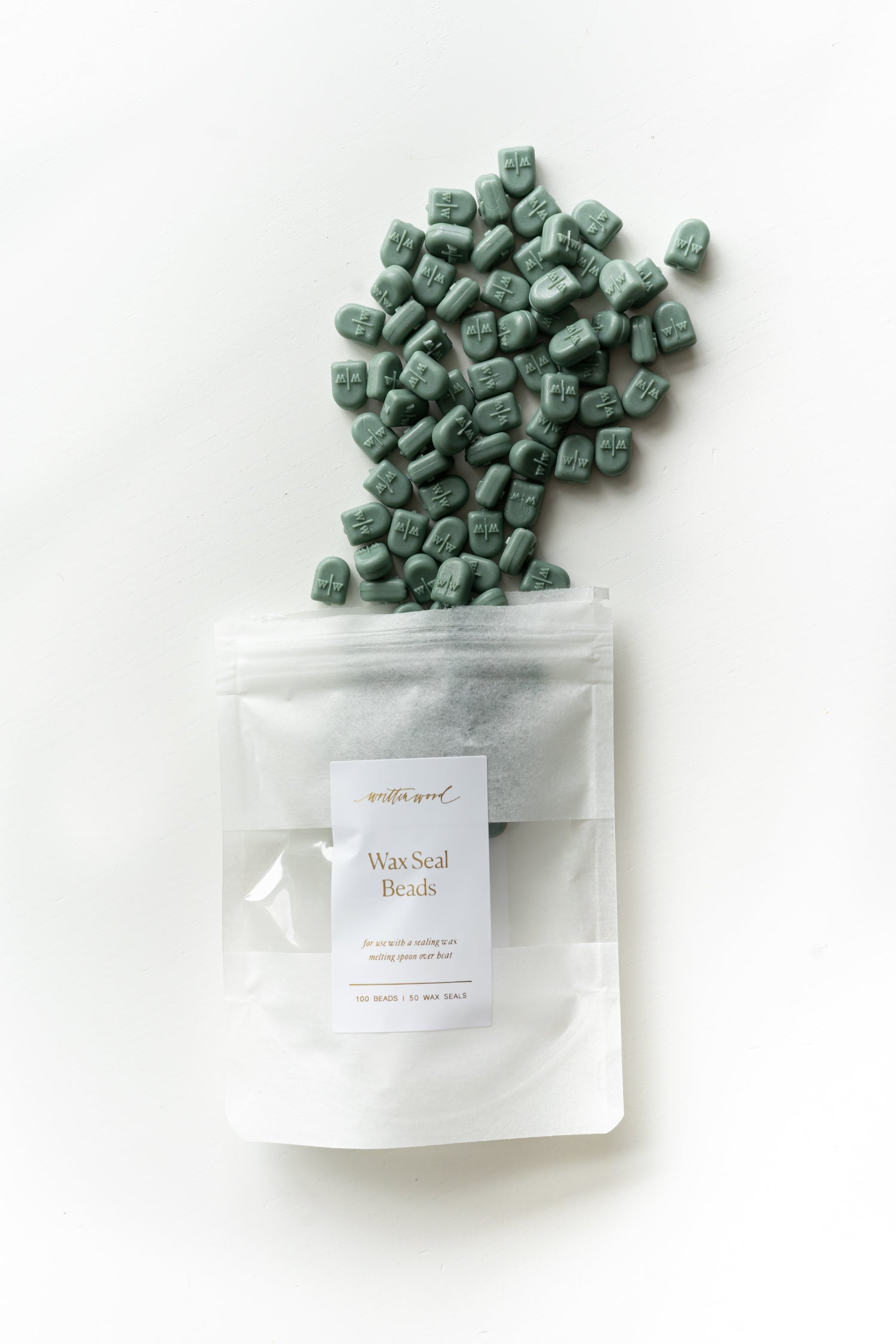 Forest green wax seal beads pouring from pouch for wax sealing projects