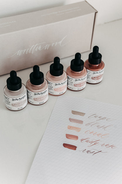 Dr. Ph. Martin's warm tone ink set with five shades: taupe, blush, coral, dusty rose, and rust, displayed with calligraphy swatches