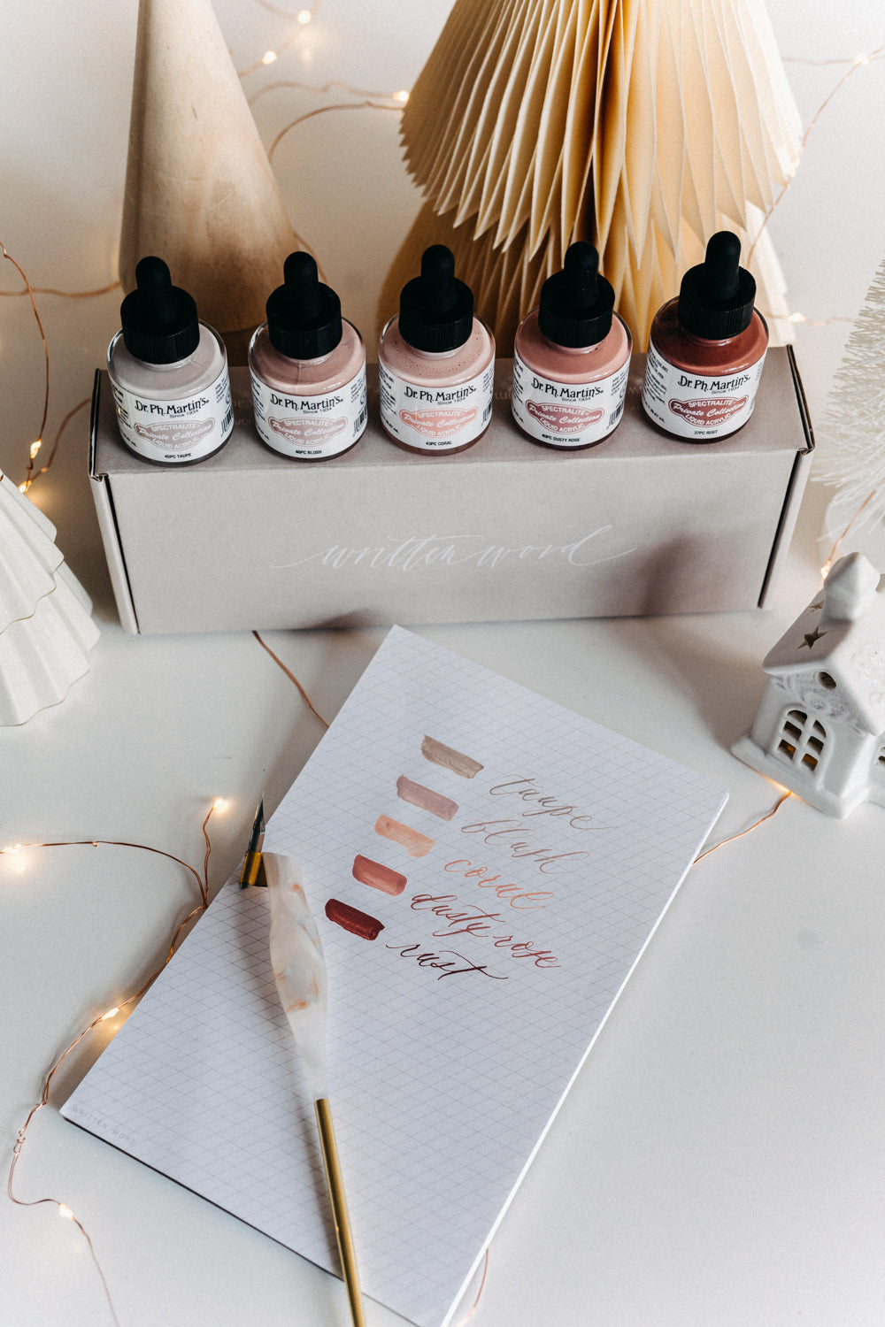 Dr. Ph. Martin's Warm Tone Calligraphy Ink Set displayed with swatches, dip pen, and festive decor on a desk