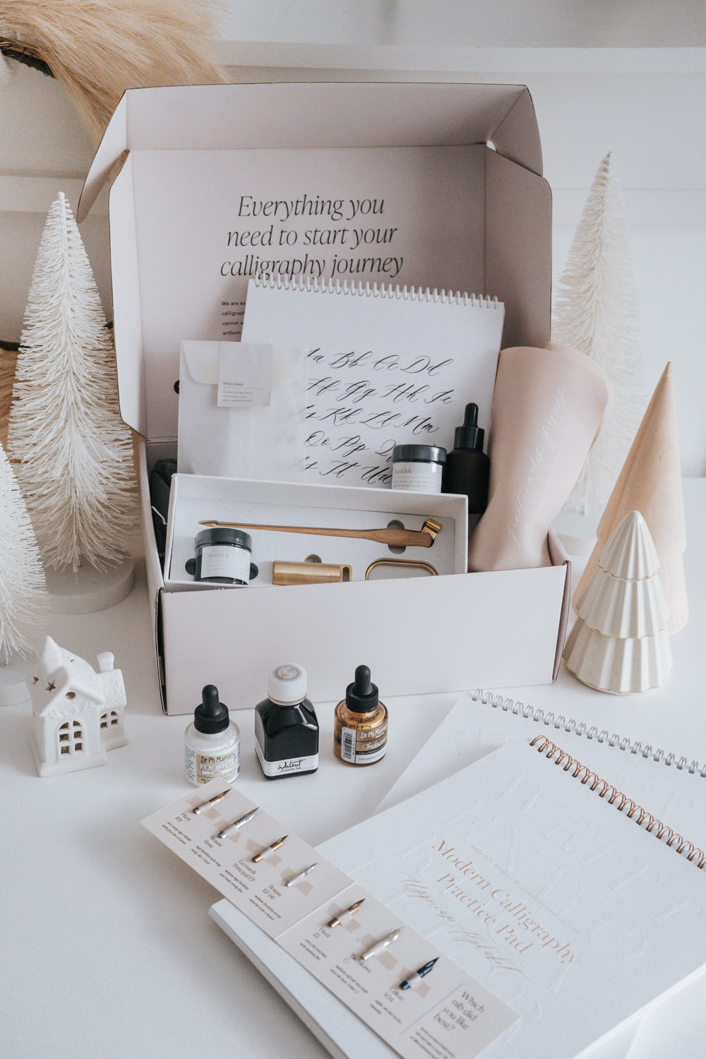 Calligraphy starter kit with supplies, ink, practice pads, and tools for beginners