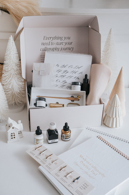 Calligraphy starter kit with supplies, ink, practice pads, and tools for beginners